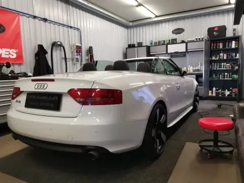 Valkoinen Audi-avoauto takaviistosta