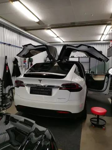 Valkoinen Tesla Model X ovet ja takaluukku avoinna