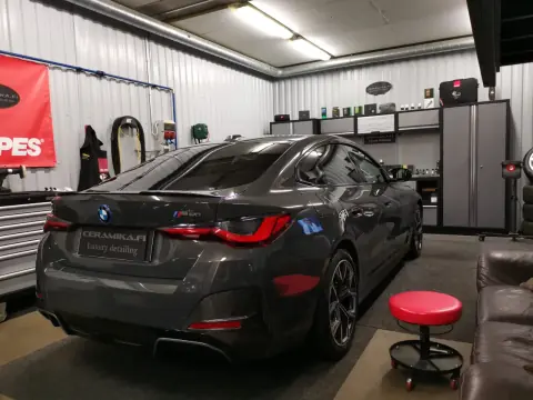 Harmaa BMW takaviistosta hallin valaistuksessa