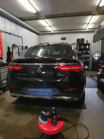 Musta Mercedes-Benz farmari takaa, vieressä kiillotuskone