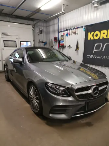 Hopeanvärinen Mercedes-Benz edestä ja sivulta
