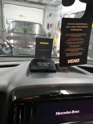 Korrek Pro Evo -pinnoitepakkaus ja pullo auton kojelaudalla