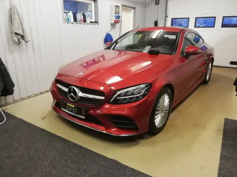 Punainen Mercedes-Benz edestä ja sivulta hallissa